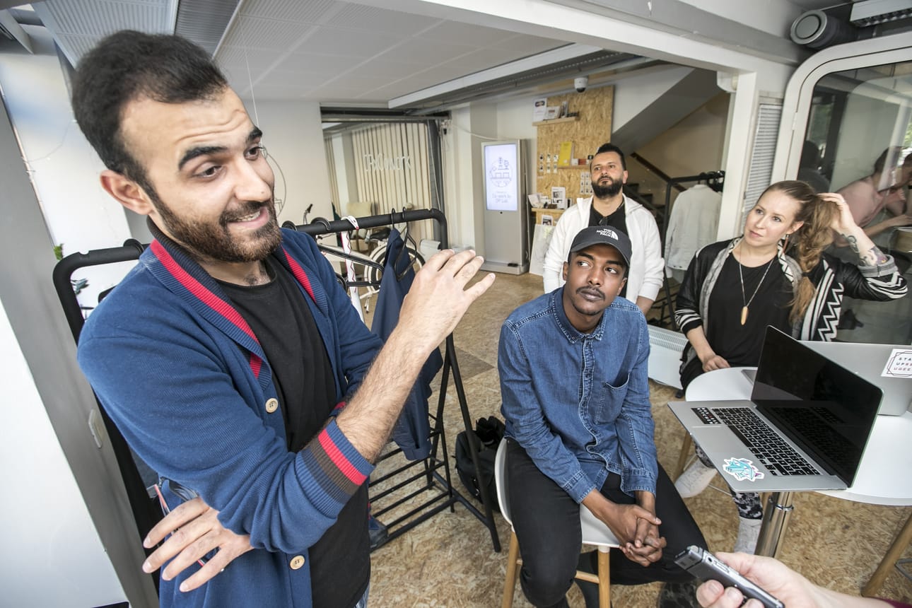 Kesätöitä löytänyt irakilainen Waleed Hlawaje (vas.) sekä muotialalle tähtäävä syyrialainen Fawaz al-Taloul (taustalla) ovat iloisia kaikesta avusta. Startup Refugeesin Matleena Aarikallio (oik.) sekä harjoittelija Ahed Hussein (kesk.) toivovat, että yrittäjät ottaisivat aktiivisesti yhteyttä työvoimatarpeiden takia.