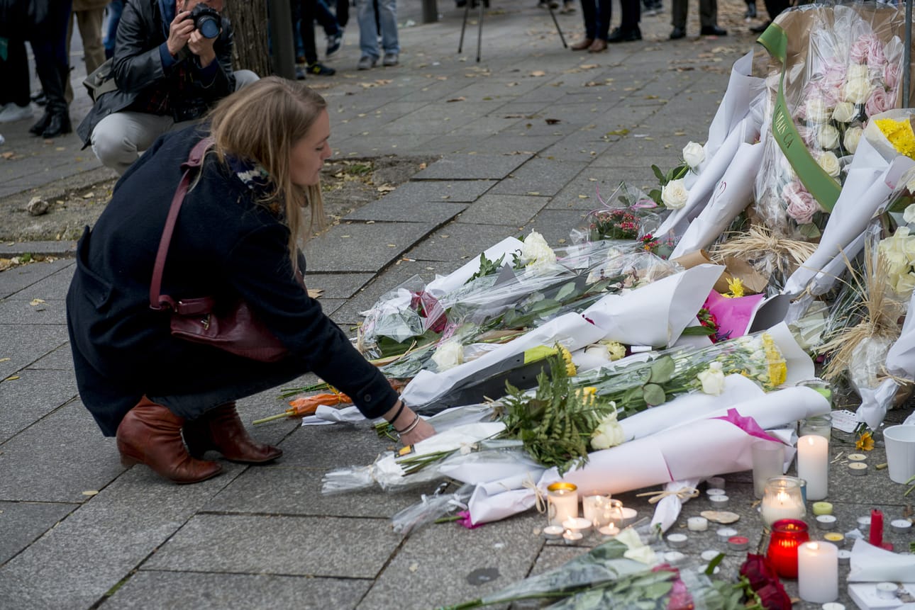 Nainen tuo kukkia keikkapaikka Bataclanin luokse lauantaina, jossa sai surmansa 80 ihmistä Pariisin iskuissa.