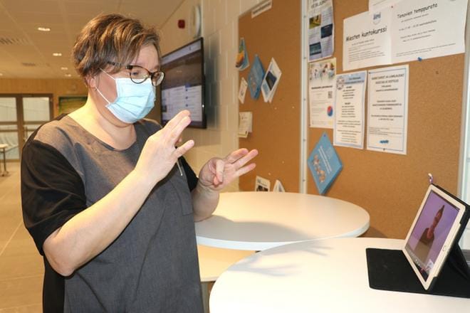 Laitoshoitajana Alajärven uimahallilla työskentelevä Kaisa Peltokangas keskustelee Alajärven uimahallilla viittomakielen tulkkinsa kanssa, joka on Seinäjoella. KUVA: SAILA COLLANDER