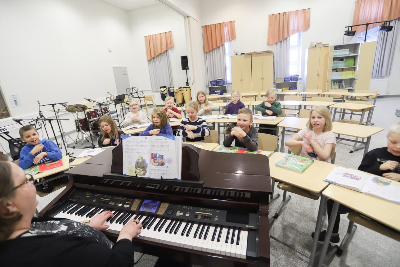 Luokanopettaja Tarja Mäkinen ja 2A-luokka tilavassa musiikkiluokassa.
