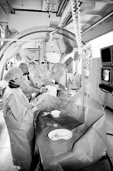 Tukoksia sepelvaltimoissa? Sairaanhoitaja Maarit Koistinaho ja osastonylilääkäri Markku Ikäheimo tekevät varjoainekuvausta Vihannissa asuvalle Olli Heikkiselle Oysin kardiologisen osaston kolmannessa angiografialaboratoriossa, joka saatiin tulipalon jälkeen uudelleen käyttöön pari kuukautta sitten.