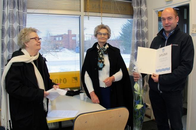 Kauhavan taksiosuuskunnan puheenjohtaja Timo Ahola vastaanotti kunniakirjan Kauhavan Invalidit ry:n Irja Pesoselta ja Aino Sahalta. KUVA: MIA KÄRKKÄINEN