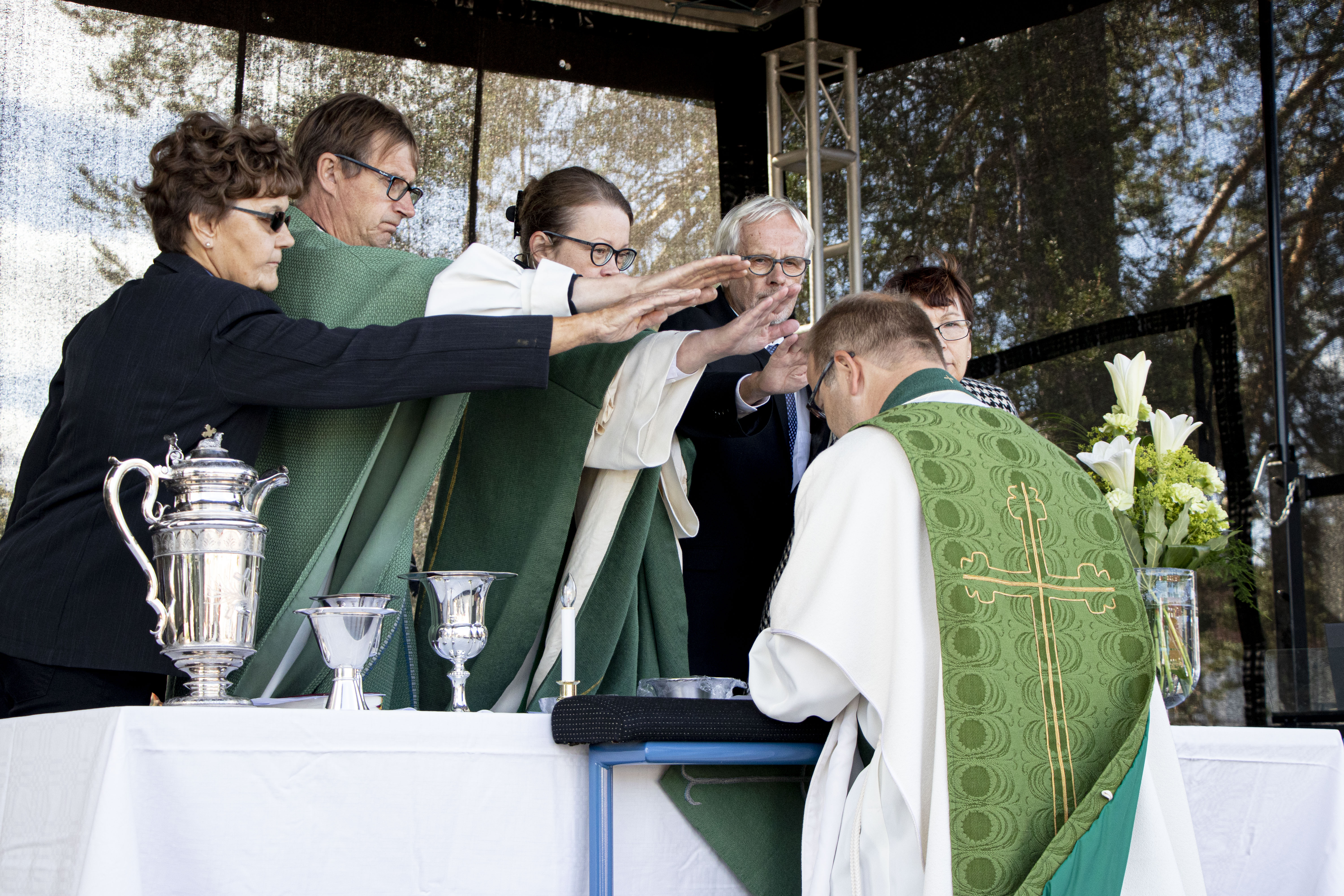 Virkaan asettamiseen kuuluu kättenpäällepaneminen. Olli Lohta siunaamassa Raahen seurakunnan kirkkoneuvoston jäsen Maija-Liisa Heikkilä, kirkkoherra Harri Joensuu, lääninrovasti Erja Oikarinen, kirkkovaltuuston puheenjohtaja Jukka Ingerttilä ja kirkkovaltuuston jäsen Anna-Maija Rahja.