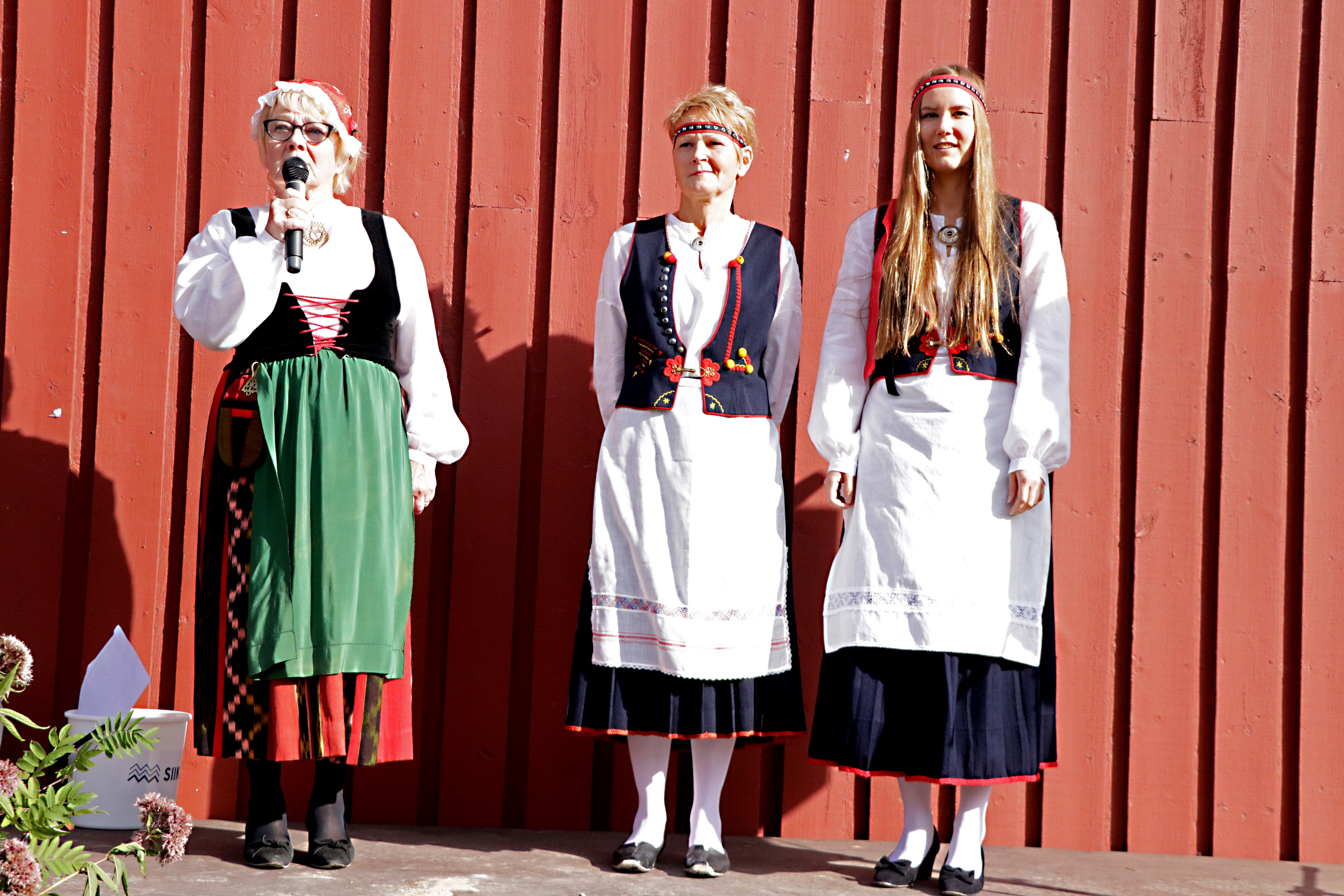 Kansallispuvut kävivät tuulettumassa markkinoilla isommalla joukolla. Tässä lavalla Marja Muhonen yllään Härmän-Isokyrön puku, Kristiina Muhosella ja Merita Heinosella on Kaukolan puku.