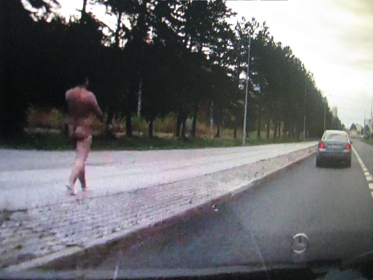 Lukijan autokamera kuvasi maanantaina kello 11 jälkeen alastoman miehen kävelemässä puhelin korvalla Tulliväylällä.