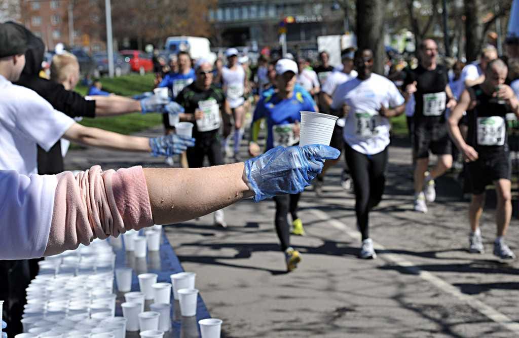 Juoksivat lähestyvät tankkauspistettä Helsingin puolimaratonilla.