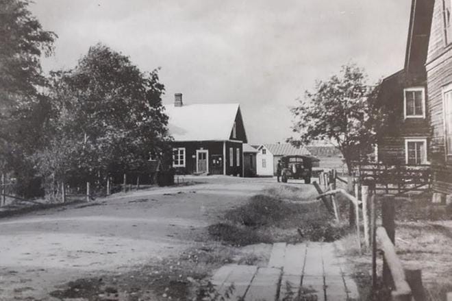 Minkä merkkinen auto ja kukahan on auton vieressä, ehkä kuljettaja? Vanhaa, noin 1930-luvun Hoiskoa kuvaava valokuva on otettu Hoiskon maamiesseuran suunnalta päin. KUVA: Kuvan lähetti Tapani Hoisko.