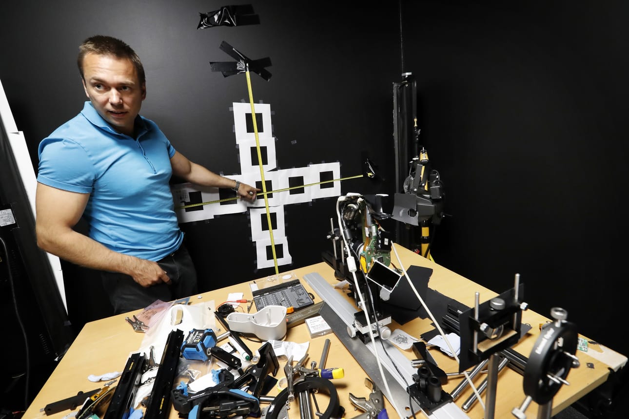 Pimeässä testaushuoneessa Optomed Oy:n toimitusjohtaja Seppo Kopsala.