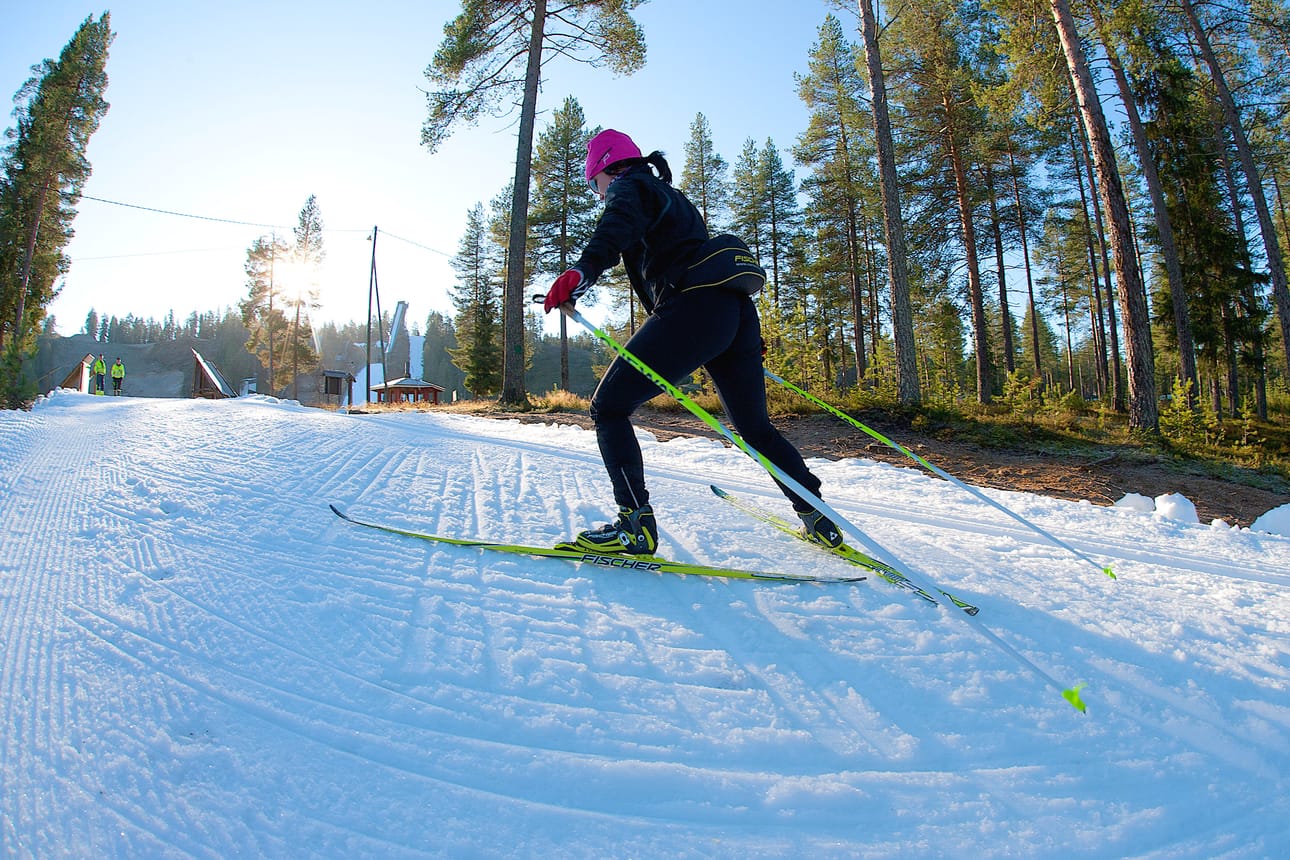 Marika Rontti hiihtää Taivalvaaran ensilumen ladulla. Laduntekijä porukkaa (vas.) seuraa silmä tarkkana sutjakkaa sivakointia.