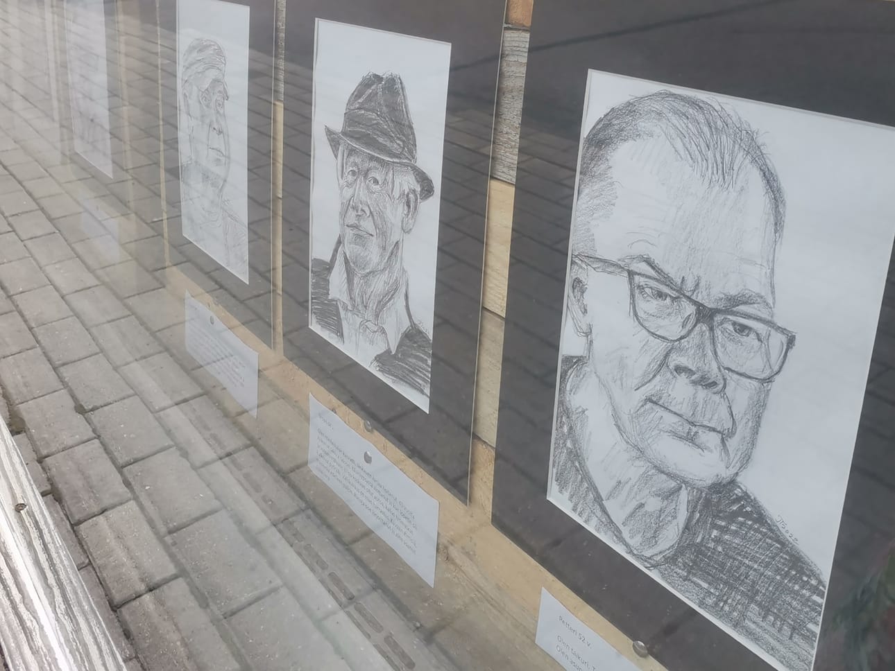 Tuttuja kasvoja katutason ikkunoissa.