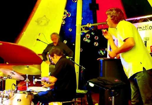 Arild Andersen Trio. Pianisti Carsten Dahl innostui puhaltelemaan saippuakuplia Patrice Héralin rumpusoolon aikana. Arild Andersen myhäilee taustalla.