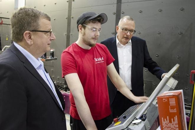 Aleksi Autio työskentelee Skaalan Ylihärmän tehtaan eristyslasilinjalla ja valvoo työn laatua välilista-automaatilla. Miestä kävivät tervehtimässä Markku Hautanen ja Christian Klinger. KUVA: JUHA AHO-PYNTTÄRI