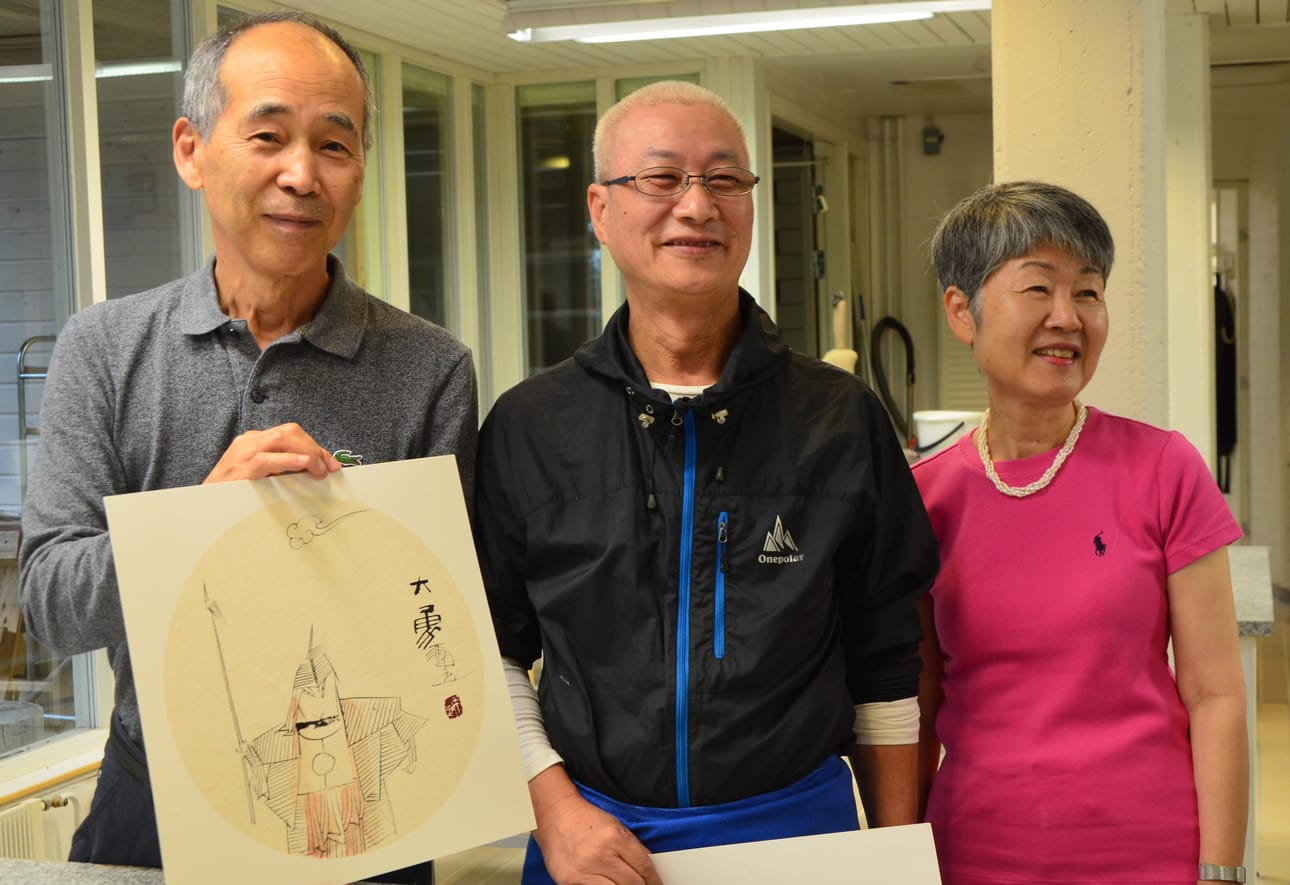 Zeng Peng (kesk.) lahjoitti Arktisen keramiikkakeskuksen voimahahmolle Suku Parkille ja hänen puolisolleen Kyung-Hee Parkille työpajassa valmistuneen maalauksen.