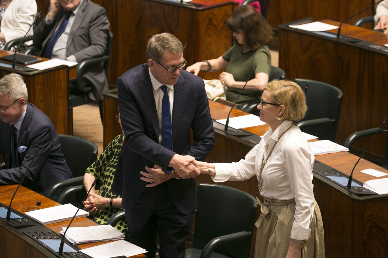 Tuore puhemies Matti Vanhanen (kesk.) saa onnittelut Paula Risikolta (kok.).