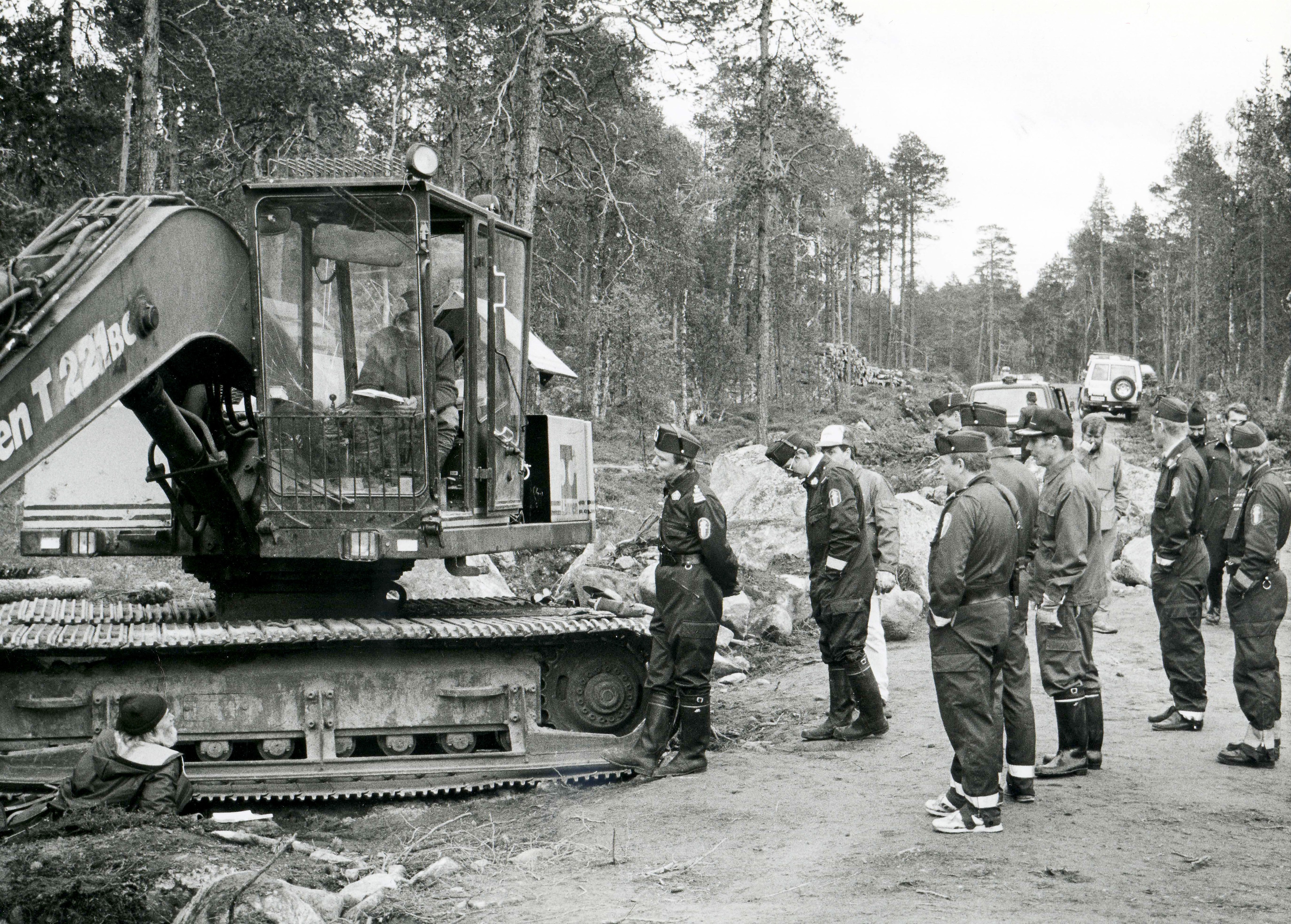 Elokuussa 1991 tunnelma Kessin metsätiellä kiristyi. Teuvo Niemelä kahlitsi itsensä kaivinkoneen telaketjuun ja Pentti Linkola hyttiin. Lopulta poliisit katkaisivat kettingit ja veivät Niemelän ja Linkolan putkaan. (Arkistokuva.)