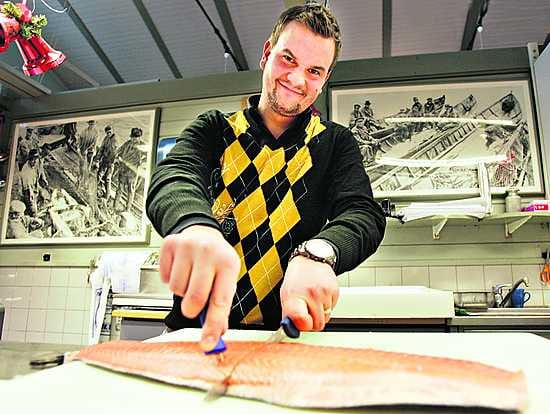 Jussi Haanpää oli keskiviikkona ensimmäistä päivää kalaliikkeen kauppiaana ja leikkasi malliksi lohimedaljonkeja.