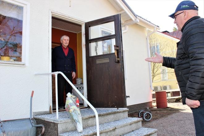 Kaupunginvaltuuston puheenjohtaja Kari Häggblom (sd.) luovutti majakkapalkinnon ja onnittelukukat kaupungin puolesta Unto Nisulalle. Koronan takia Häggblom jätti palkinnon Nisulan rappusille. KUVA: LOTTA KALLIO