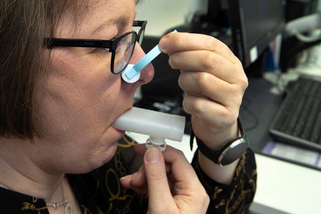 Annette Kainu puhaltaa spirometriamittariin. Puhalluksien ajaksi nenä suljetaan.