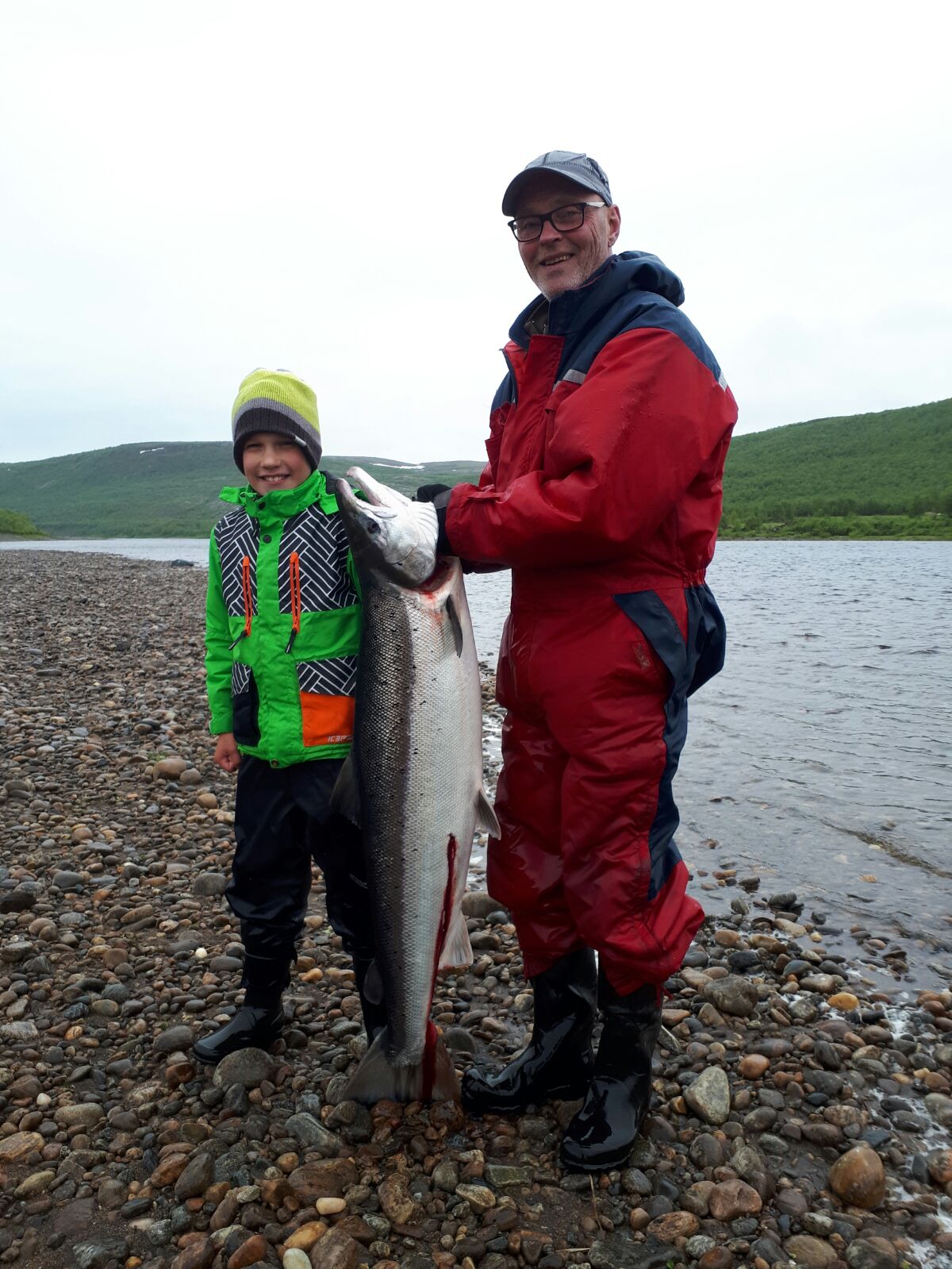 Hymy on herkässä näillä kalamiehillä, eikä suotta! Kala-Kalle väsytteli juuri 17,6 kg:n Tenon lohen, melkoinen suoritus 11- vuotiaalta! Kuvassa myös Erkki-pappa, kuvaajana isä Juha.