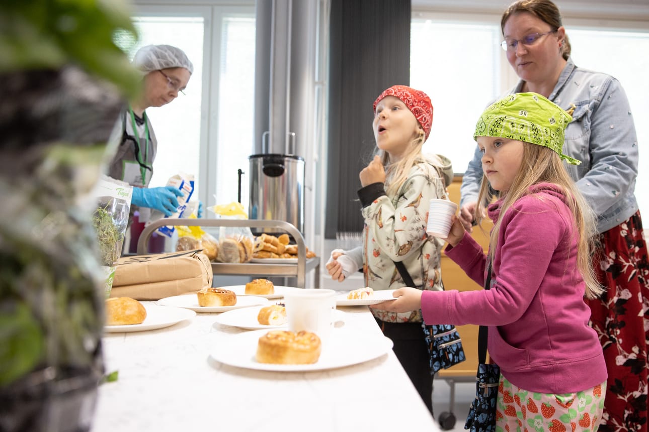 Pihla ja Annu Korhonen pääsivät maistamaan pullia äitinsä Kaisa Korhosen kanssa Kumppanuustalo Nuotan hävikkijakelussa.