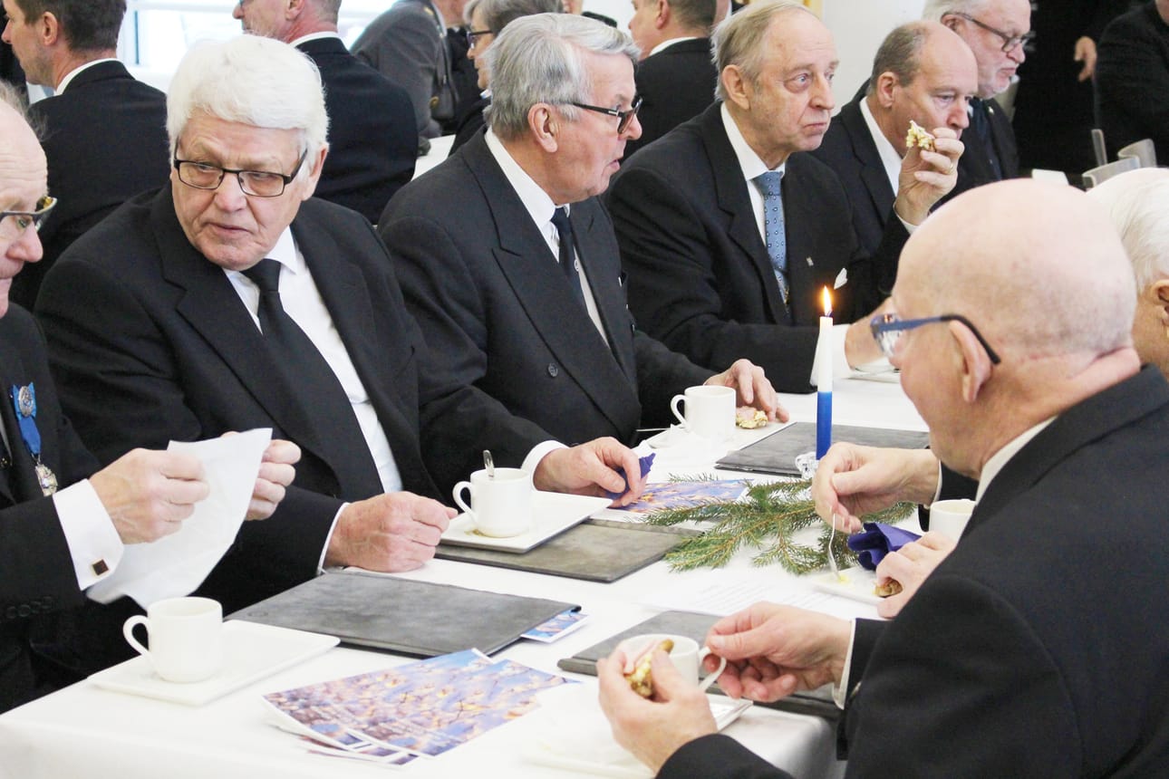 Perinnekuoron laulajia kahvilla.