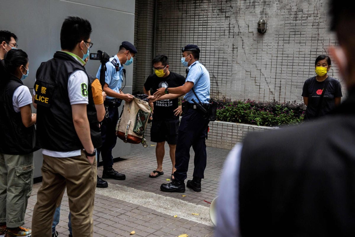 Poliisit tutkivat demokratia-aktivistin kassia protestin yhteydessä Hongkongissa viime kesänä. LEHTIKUVA/AFP
