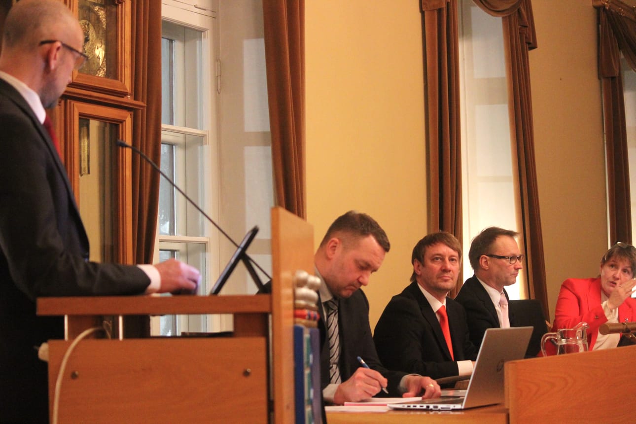 Mila Segervall vastaamassa puhujapönttöön nousseelle Henrik Antfolkille. Pitkän pöydän takana myös Kristiinan lakimies, elinvoimaisuuden palvelualueen johtaja Niklas Granö, valtuuston puheenjohtaja Peter Grannas ja kaupunginhallituksen puheenjohtaja Thomas Söderlund.