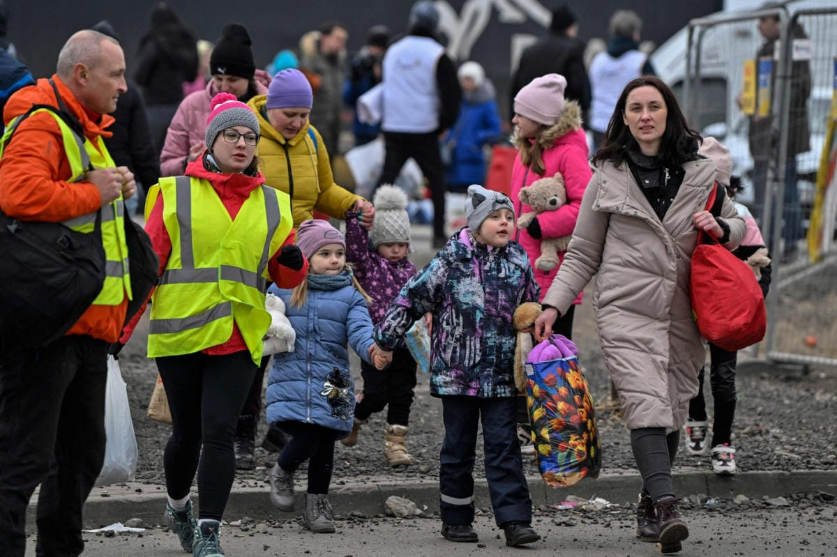 Puolan rajalla vapaaehtoiset auttoivat Ukrainasta pakenevia perheitä maaliskuun 6. päivä. LEHTIKUVA/AFP