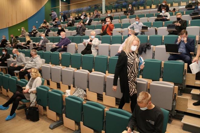 Kaupunginvaltuusto kokoontui ensimmäisen kerran uuden koulukeskuksen auditoriossa. Lattiaa suojeltiin pukemalla siniset muovitossut, omaa ja toisten terveyttä maskeilla. KUVA: ANU NAHKALA