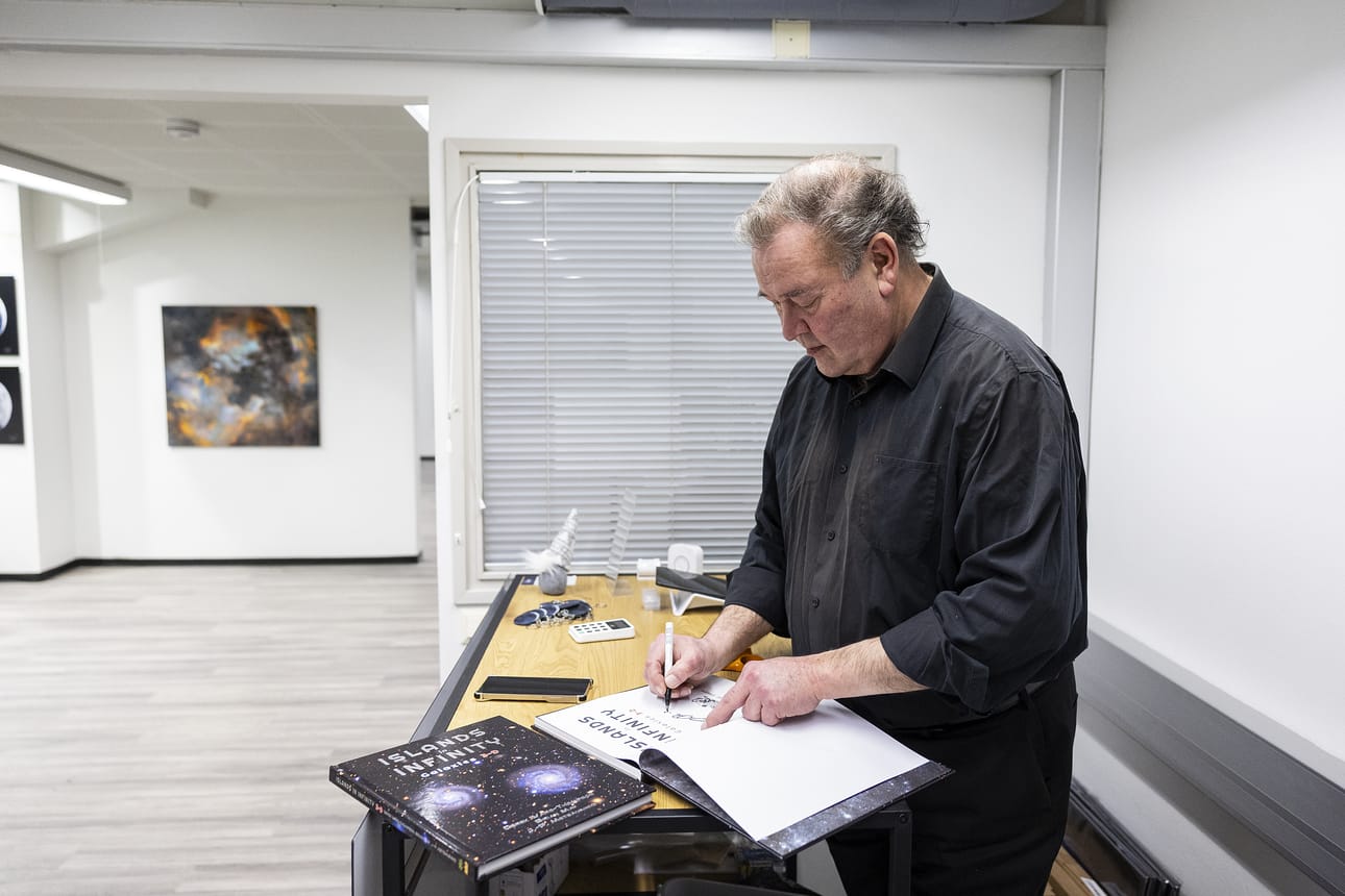 J-P Metsävainio signeeraa Islands in infinity -teosta. Hän on on yksi teoksen tekijöistä. Arkistokuva.