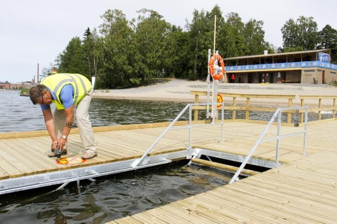 Hietasaaren uusi uintilaituri jakautuu kahtia. Haarojen päässä on mereen johtavat portaat. Haarojen keskellä on liikuntaesteisille tarkoitettu alue, josta pääsee kaiteiden avulla pulahtamaan portaita pitkin vedessä olevalle uintitasolle. Laiturivastaava Keijo Taipalus kiinnitti torstaina sukeltaminen ja hyppääminen kielletty -merkkejä. KUVAT: ANNE LAURILA