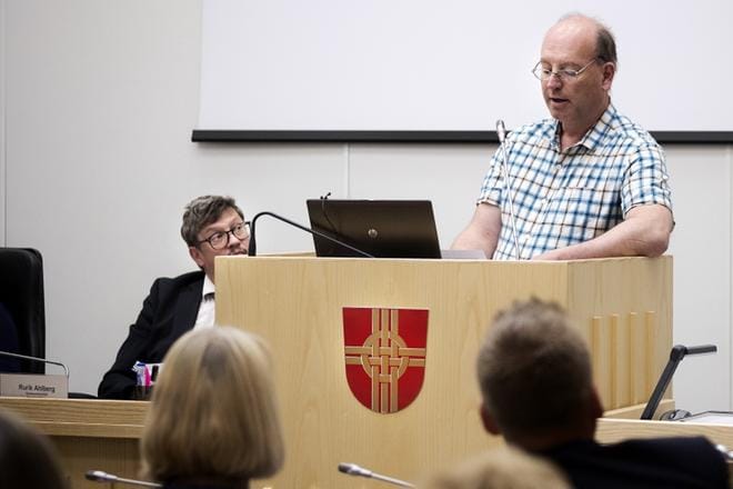RKP:n Per-Henrik Lithén esittää valtuustoaloitteessaan kuntaliitosneuvottelujen pikaista keskeyttämistä. Kunnanjohtaja Rurik Ahlberg, valtuutetut ja muut paikalla olleet kuuntelivat kiinnostuneina Lithénin perustelut. KUVA: JARNO PELLINEN
