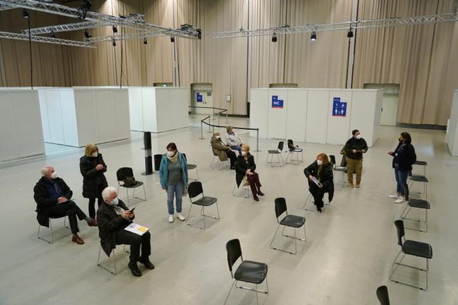 Ihmisiä istumassa rokotuskeskuksen tarkkailualueella Saksan Potsdamissa sen jälkeen, kun nämä olivat saaneet koronarokotteen. KUVA: Sean Gallup / epa
