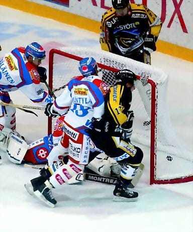 Tahdonvoimalla. Kärppien keskushyökkääjä Mika Pyörälä vääntää ratkaisevan 3-1-osuman, vaikka Tappara-puolustaja Tuukka Mäntylä roikkuu oululaisen reppuselässä.