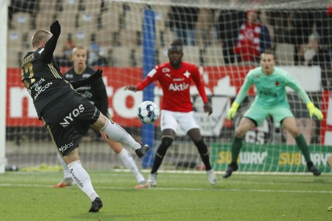 SJK:n Ville Tikkanen yrittää ampua maaliin HIFK:n maalivahti Markus Uusitalon pitäessä vahtia jalkapallon Veikkausliigan mestaruussarjan ottelussa HIFK vastaan SJK Helsingissä lauantaina. Kuva: Lehtikuva / Roni Rekomaa