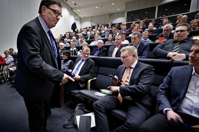 Onko tässä vapaata, kysyy kokoukseen jo sen alettua saapunut Paavo Väyrynen Antti Kurviselta. Juha Sipilä seuraa tilanteen kehittymistä vierestä. Väyrysen vierailu Etelä-Pohjanmaan keskustapiirin kevätkokouksessa ei sujunut aivan suunnitelmien mukaan, sillä hän ei onnistunut saamaan taksia riittävän ajoissa ja myöhästyi pohjoiseen menevästä junasta. KUVA: TOMI KOSONEN