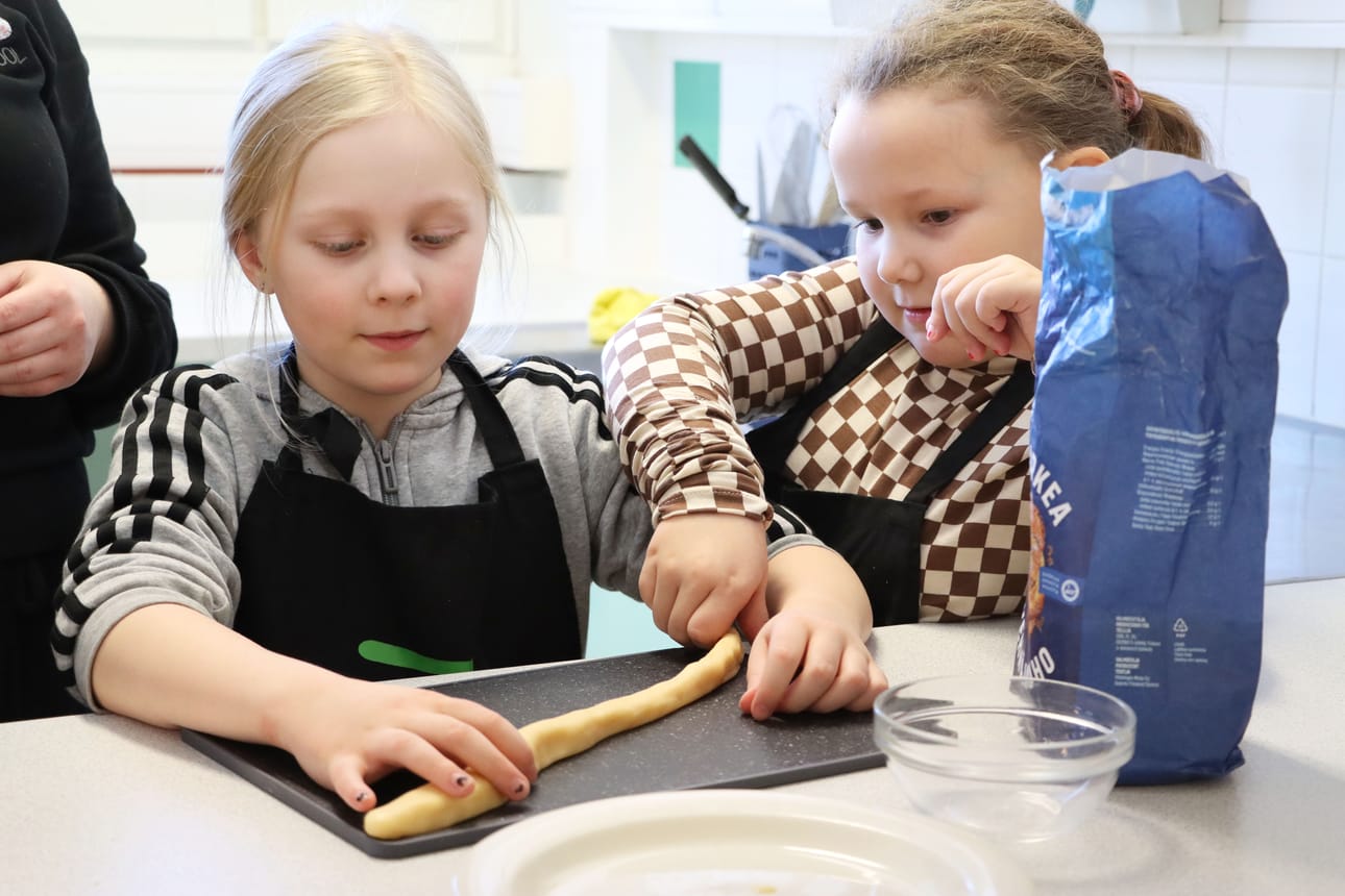 Irmeli Isomäki ja Aada Vedenpää muotoilivat pötkön kermakarkkimassasta.