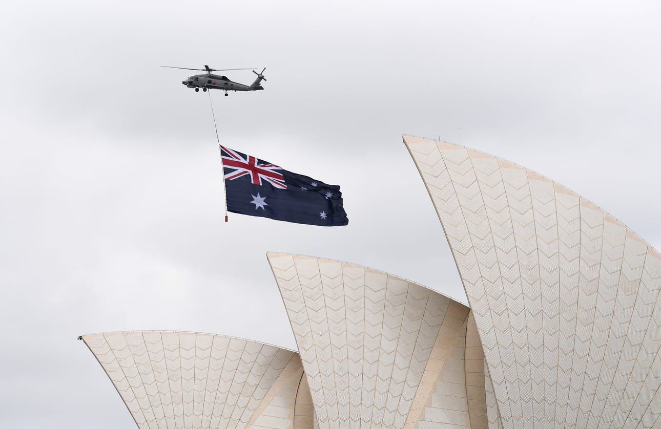 Australian lippu lentomatkalla Sydneyn oopperatalon yllä Australia Day -juhlallisuuksien aikaan 26. tammikuuta 2017. Päivänä juhlistetaan ensimmäisten uudisasukkaiden saapumista maahan. Kriitikot pitävät päivää aboriginaalien sorron alkupäivänä, eikä päivää pitäisi heidän mukaansa juhlistaa.