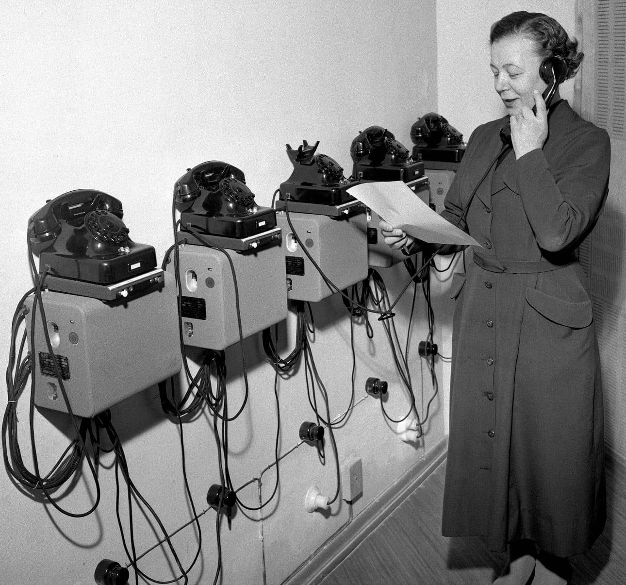 Nainen puhuu puhelimeen 1950-luvulla.