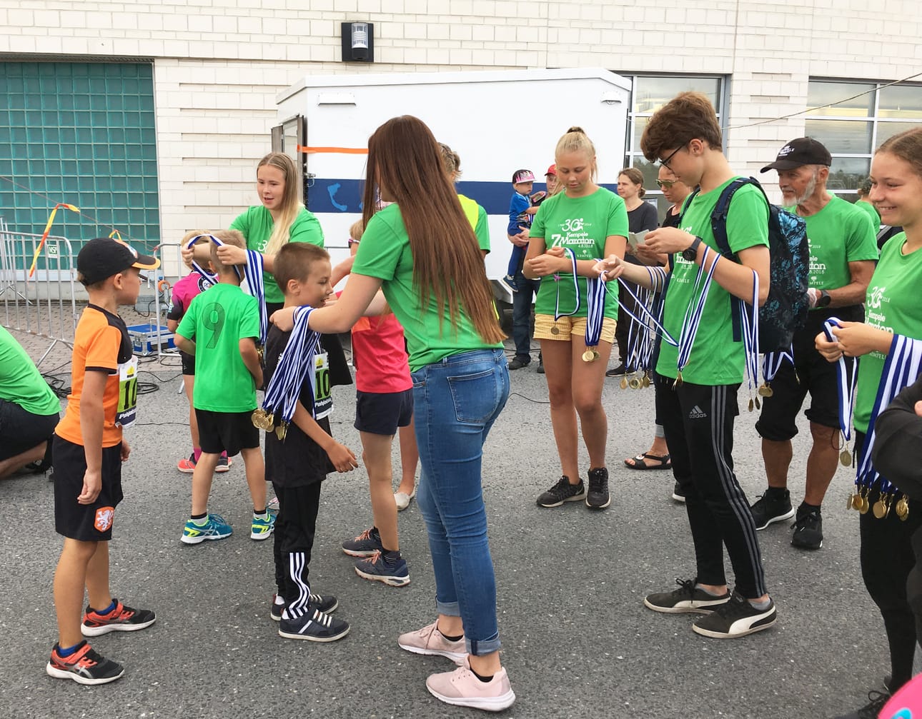 Lauantaina Kempeleen Z-Maratonilla toimitsijoina avustaneet Partiolippukunta Samposten Jamboree-nuoret sujauttivat mitalit Minimaratoonareiden kaulaan heti maaliviivan jälkeen.