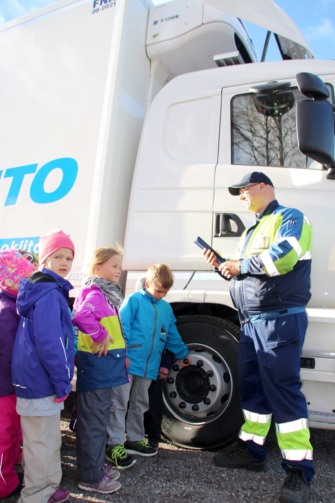 Kuorma-autonkuljettaja Tero Anttonen järjesti Revonlahden lapsille heijastintempauksen. Hän jakoi heijastinnauhoja, tutustutti kuoma-autoon sekä kertoi mitä kopista näkee ja mitä ei. Kuva: Kirsi Junttila