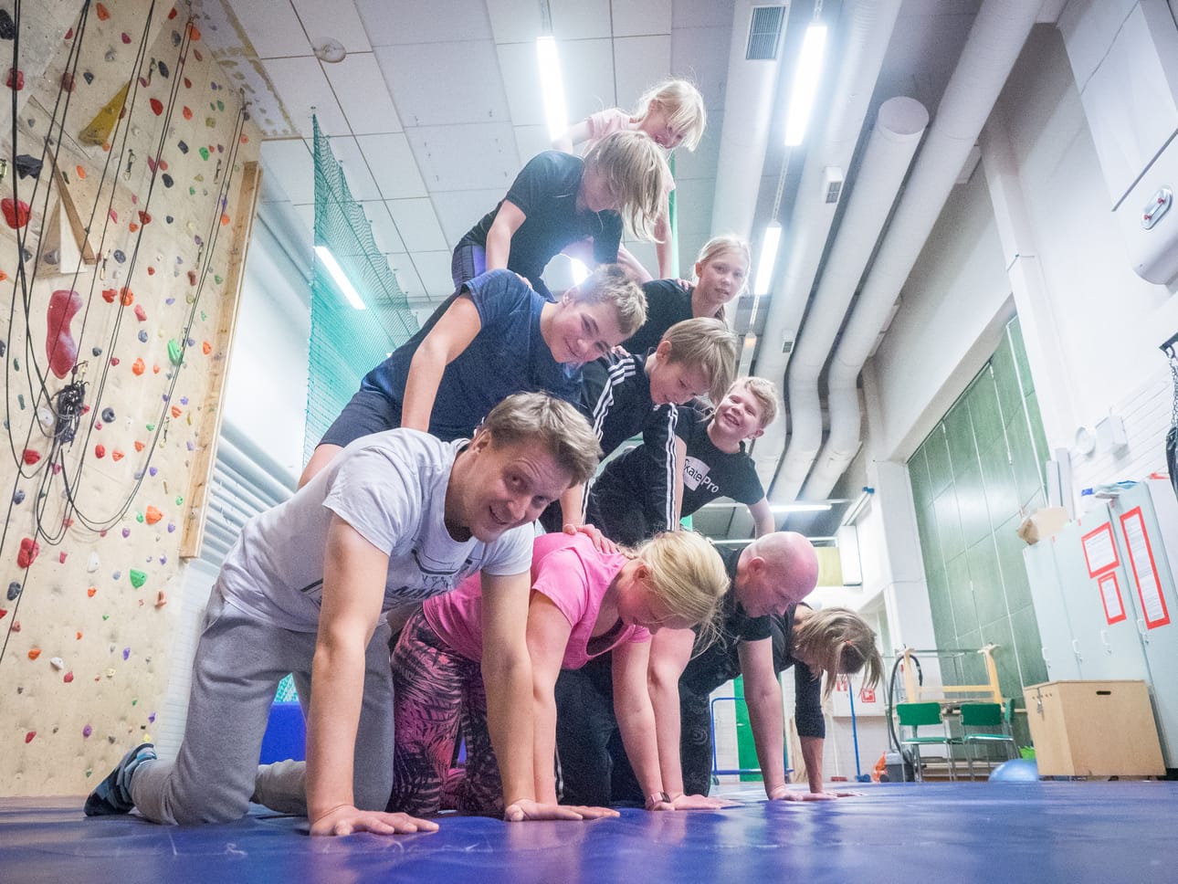 Kurssin opettaja Hannes Määttä (vasemmalla alimmaisena) opastaa kurssilaisia ihmispyramidin teossa.