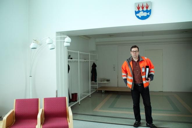 Tekninen johtaja Martti Ranta seisoo Kuismankartanon aulassa. Hänen takanaan näkyy seinä, joka on rakennettu vanhan ja uuden osan väliin estämään epäpuhtauksien kulkeutuminen uudelle puolelle. KUVA: KAROLIINA SYRJÄ