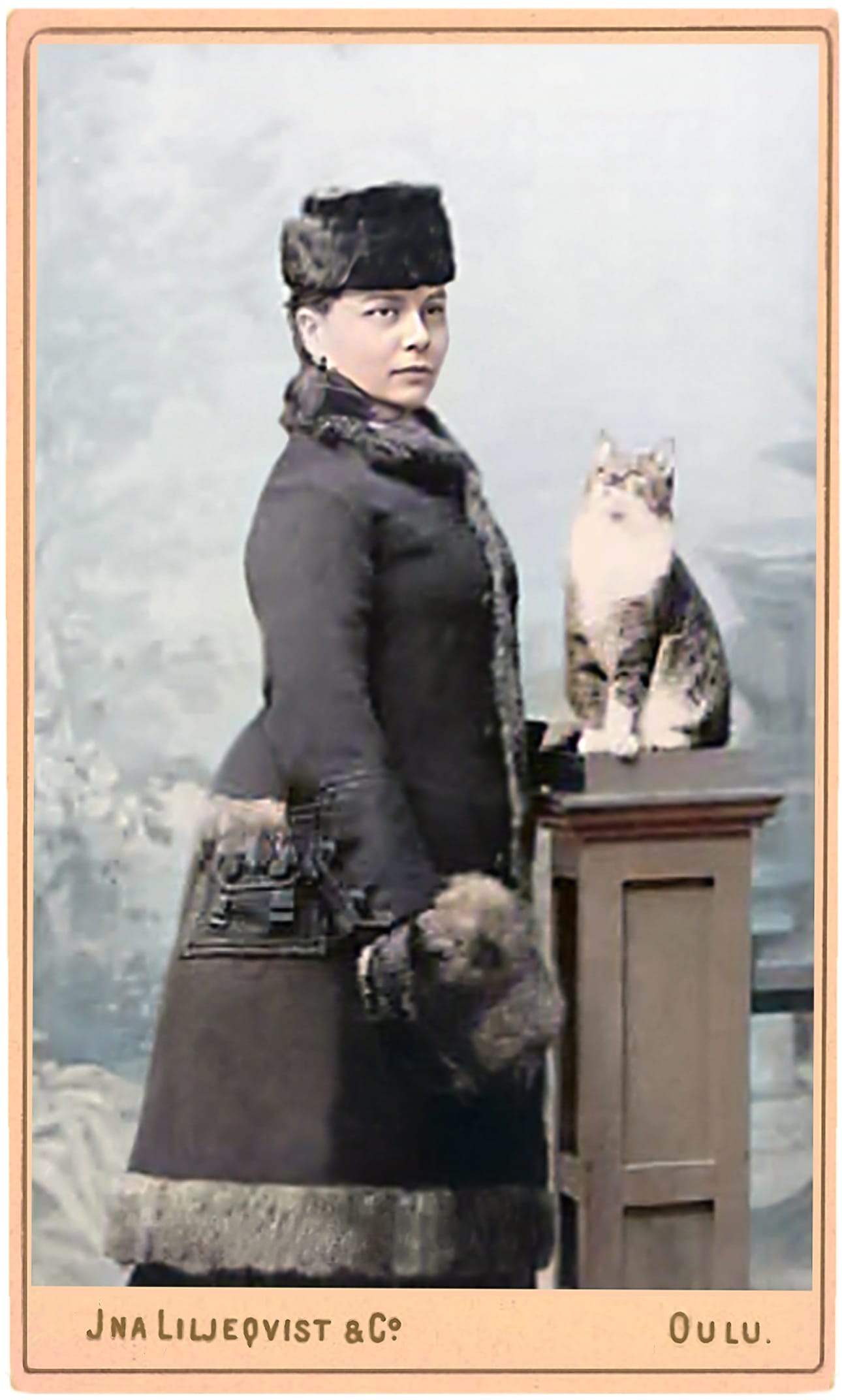 Sisätiloissa kuvatuissa henkilökuvissa Liljeqvist käytti ajalle tyypilliseen tapaan oheisrekvisiittaa. Myös hänen omakuvansa taustalla näkyy maalattu maisemakulissi ja valokuvaajan vieressä oma kissa korotetulla puujalustalla. Digitaalisesti väritetty alkuperäinen mustavalkokuva on todennäköisesti 1880-luvun lopulta.