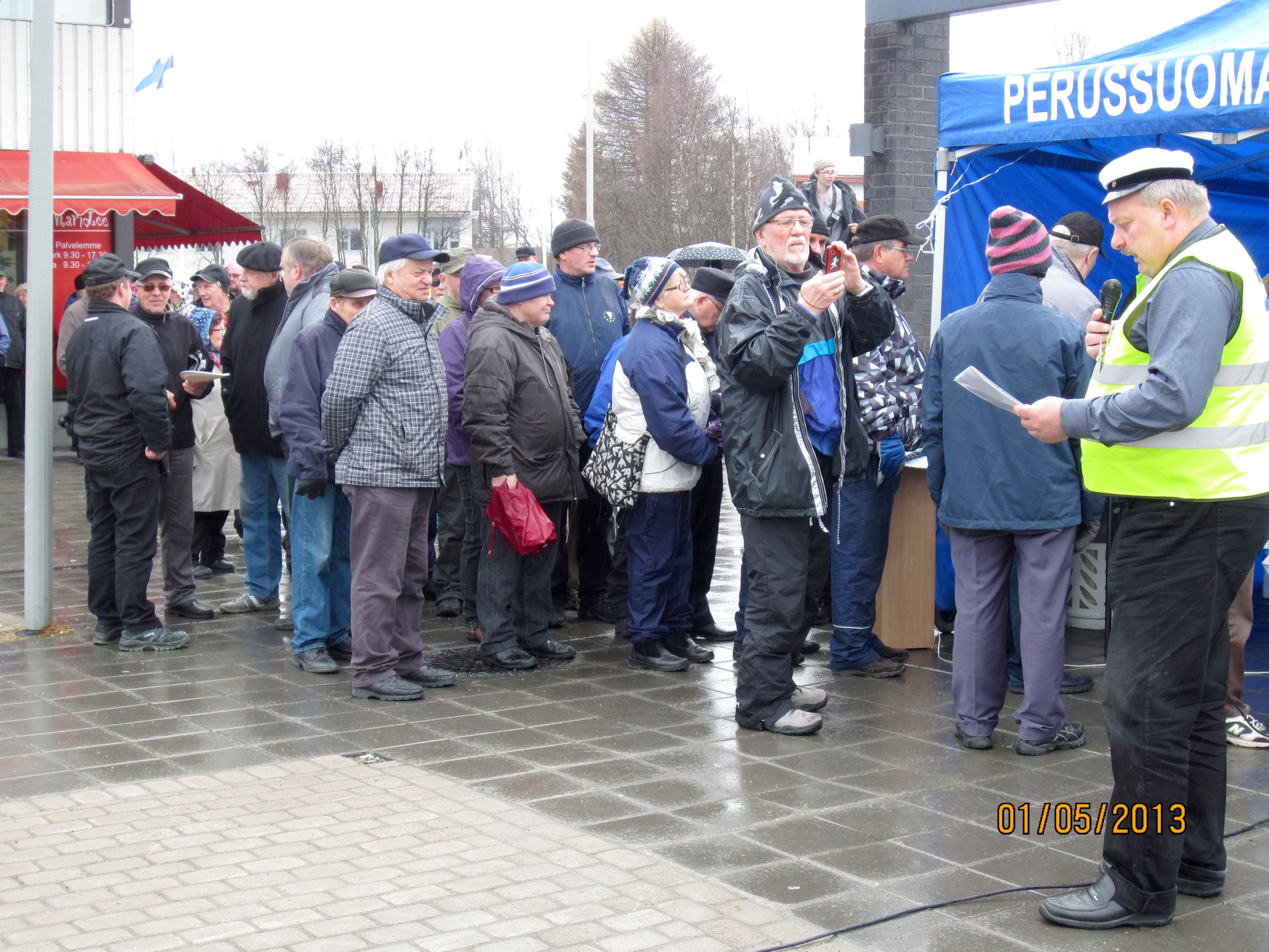 Vappuna 2013 jonotettiin perussuomalaisten tarjoiluja sadesäässä.