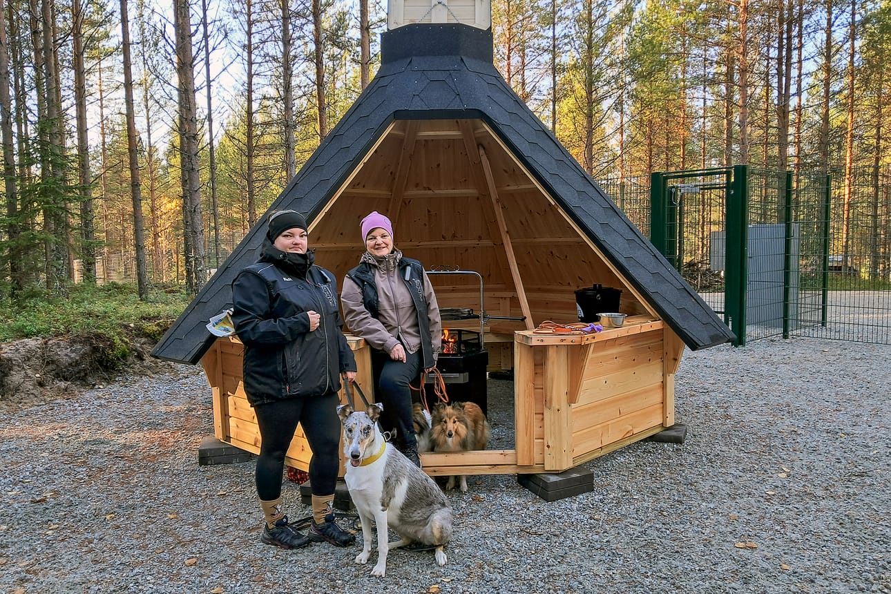 Katri Hendriksson ja Maija Saarenpää Kemin koirametsän kotalaavulla. Katrin sileäkarvainen collie Inari tykkää omistajansa mukaan "juosta reikäpäänä". Aidattu alue sallii koiran irti pitämisen. Meri-Lapin Koiraklubin aktiiveina naiset toivovat, että paikat koirametsässä pysyisivät siisteinä.