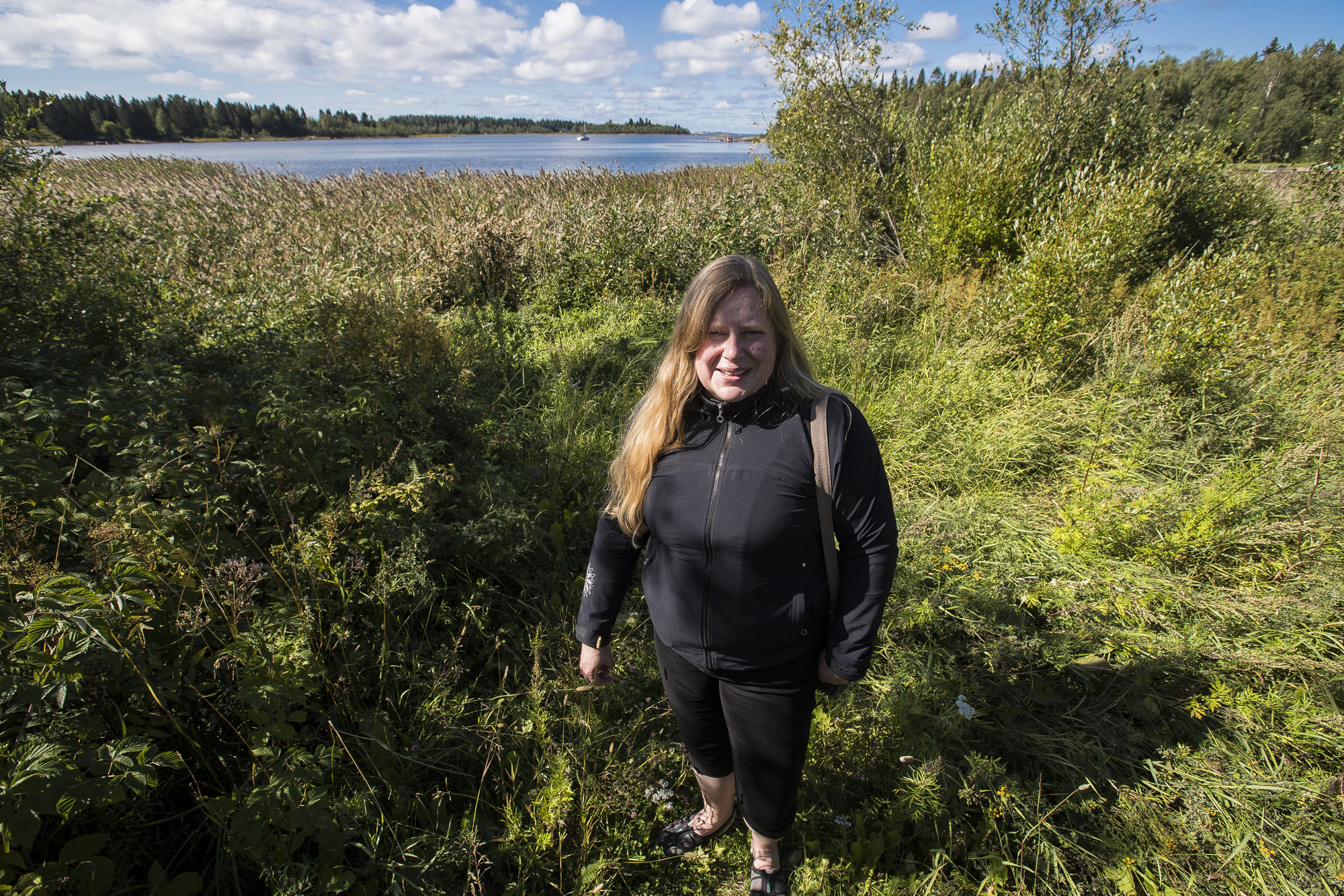 Kaavasuunnittelija Outi Järvinen suunnilleen Ruottalonlahden asuntoalueen tulevan laiturin paikalla. Rannasta on suora näköyhteys Taskun saareen.