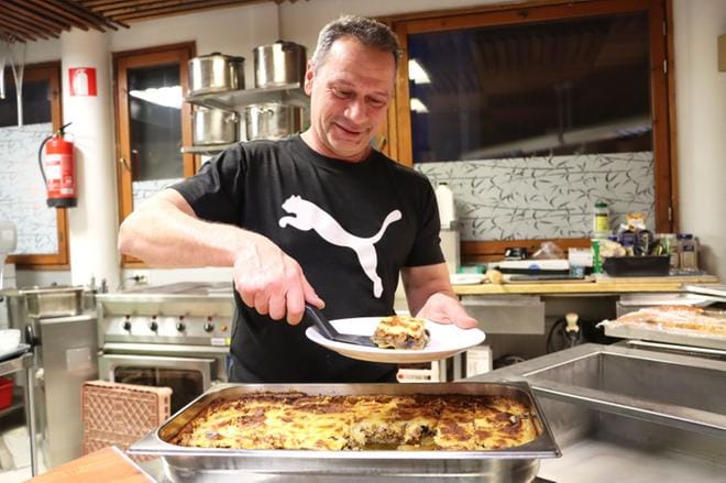 Fadi Sadik nostaa lautaselle perinteistä kreikkalaista moussakaa. KUVA: EEVA-LIISA KULJU