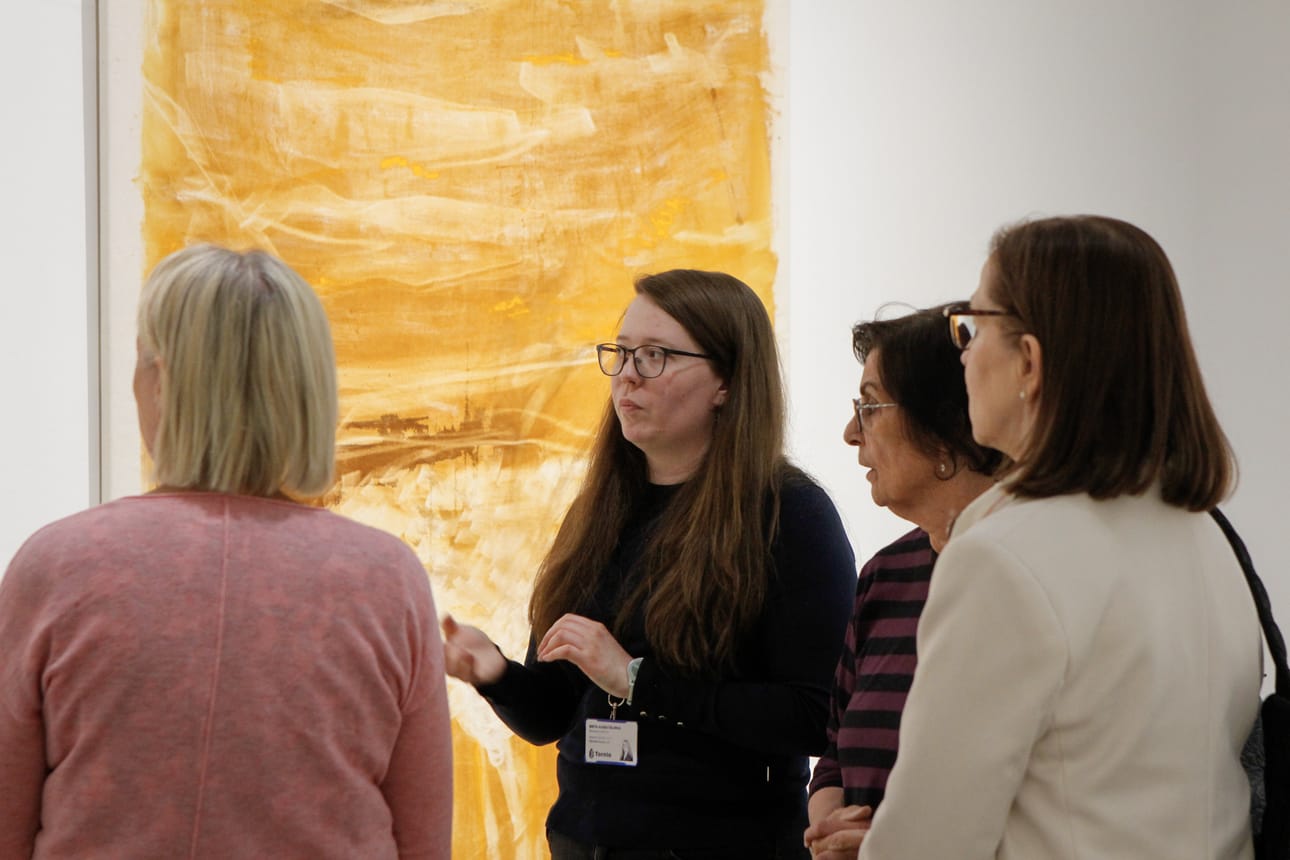 Museoassistentti Brita-Kaisa Välimaa esittelee osallistujille Aineen taidemuseon kokoelman teoksia.