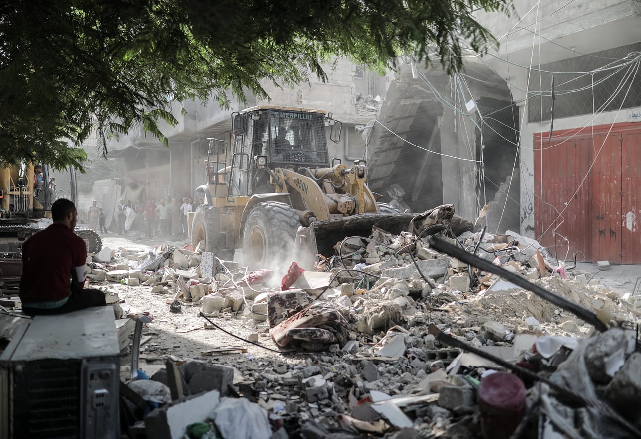 Israelin ilmaiskun tuhoaman asuinrakennuksen jäänteitä siivottiin Gazan eteläosissa sunnuntaina.